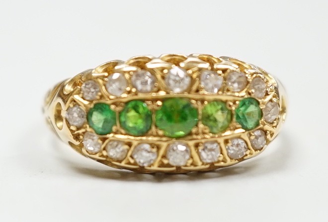 An Edwardian 18ct gold, demantoid garnet and diamond set oval cluster half hoop ring, size L, gross weight 3 grams.
